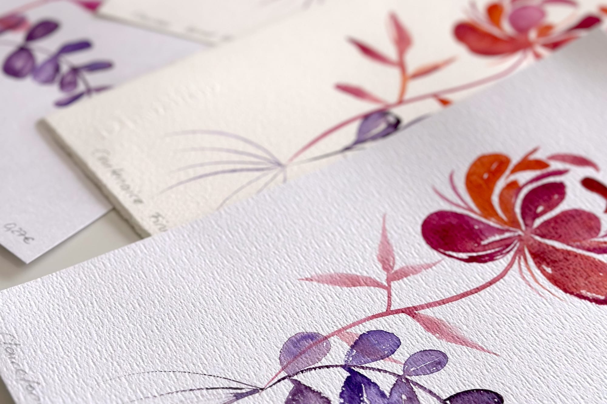 Florale Aquarell-Motive in Rosa, Rot und Violett auf feinem Papier