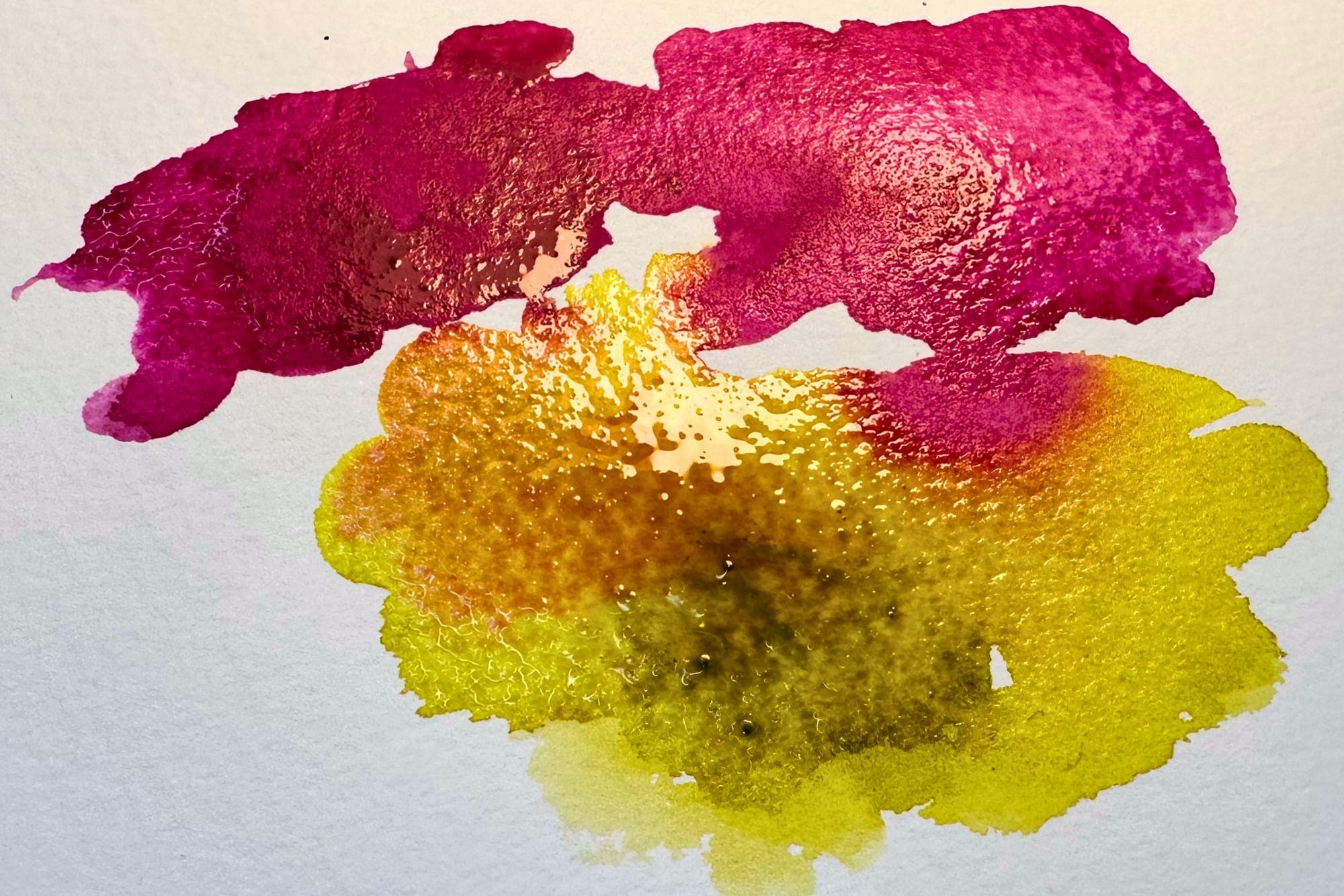 Nahaufnahme zweier Aquarellfarben, die nass in nass ineinanderfließen