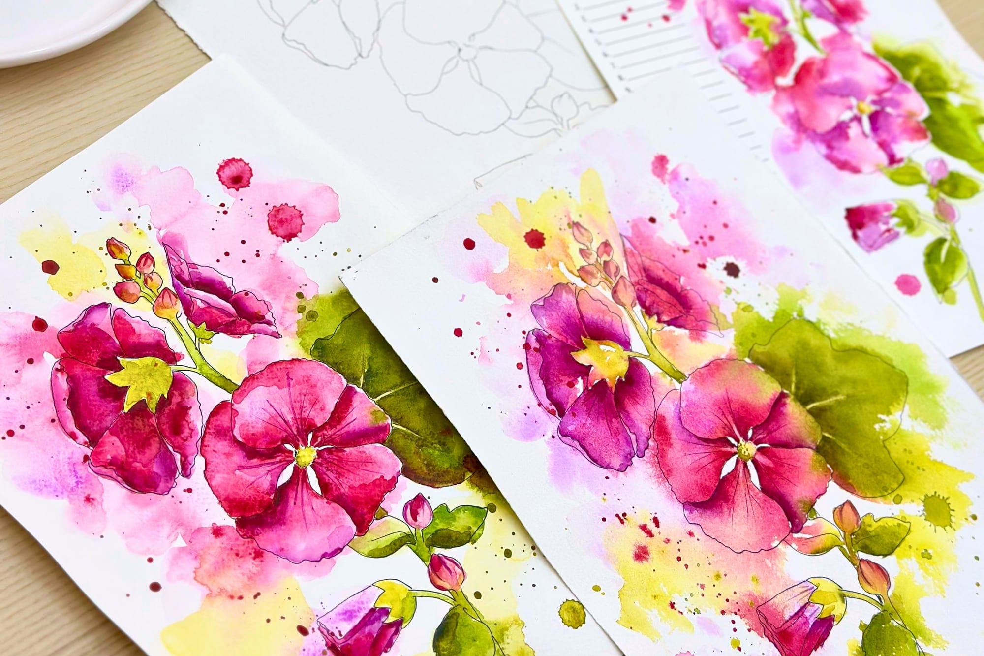 Aquarelle von Stockrosen in Pink und Grün, daneben die Bleistiftskizze